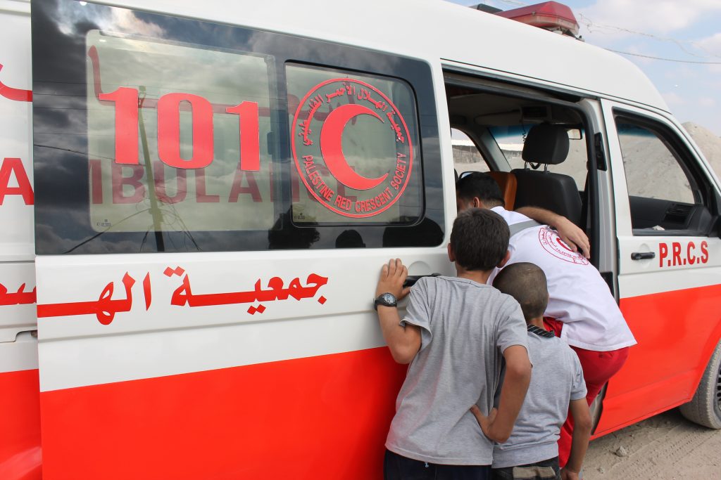 PRCS medics help a demonstratorsuffering from teargas inhalation at ademonstration at Nahal Oz checkpoint- September 2013(Photo taken by Joe Catron)